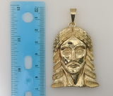 A gold plated pendant featuring a cross symbol
A gold plated pendant shaped like a cross
A gold plated pendant with a Je